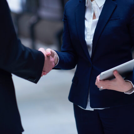 partnership concept with business man and woman hand shake and take agreement in modern office interior